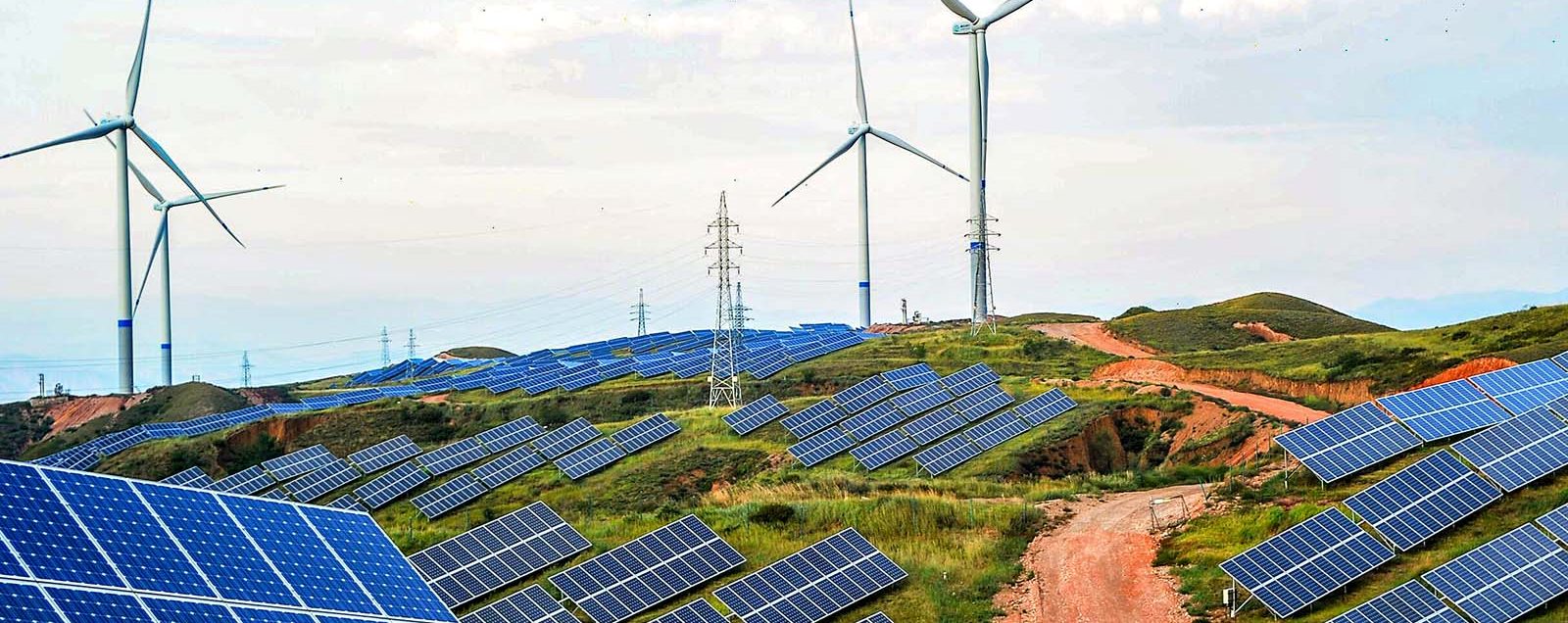 ZHANGJIAKOU, CHINA - JULY 02: Solar panels and wind turbines are pictured on a barren mountain at Shenjing Village on July 2, 2018 in Zhangjiakou, Hebei Province of China. The installed capacity of renewable energy electricity generation in Zhangjiakou has reached 12.03 million kilowatts. (Photo by VCG)